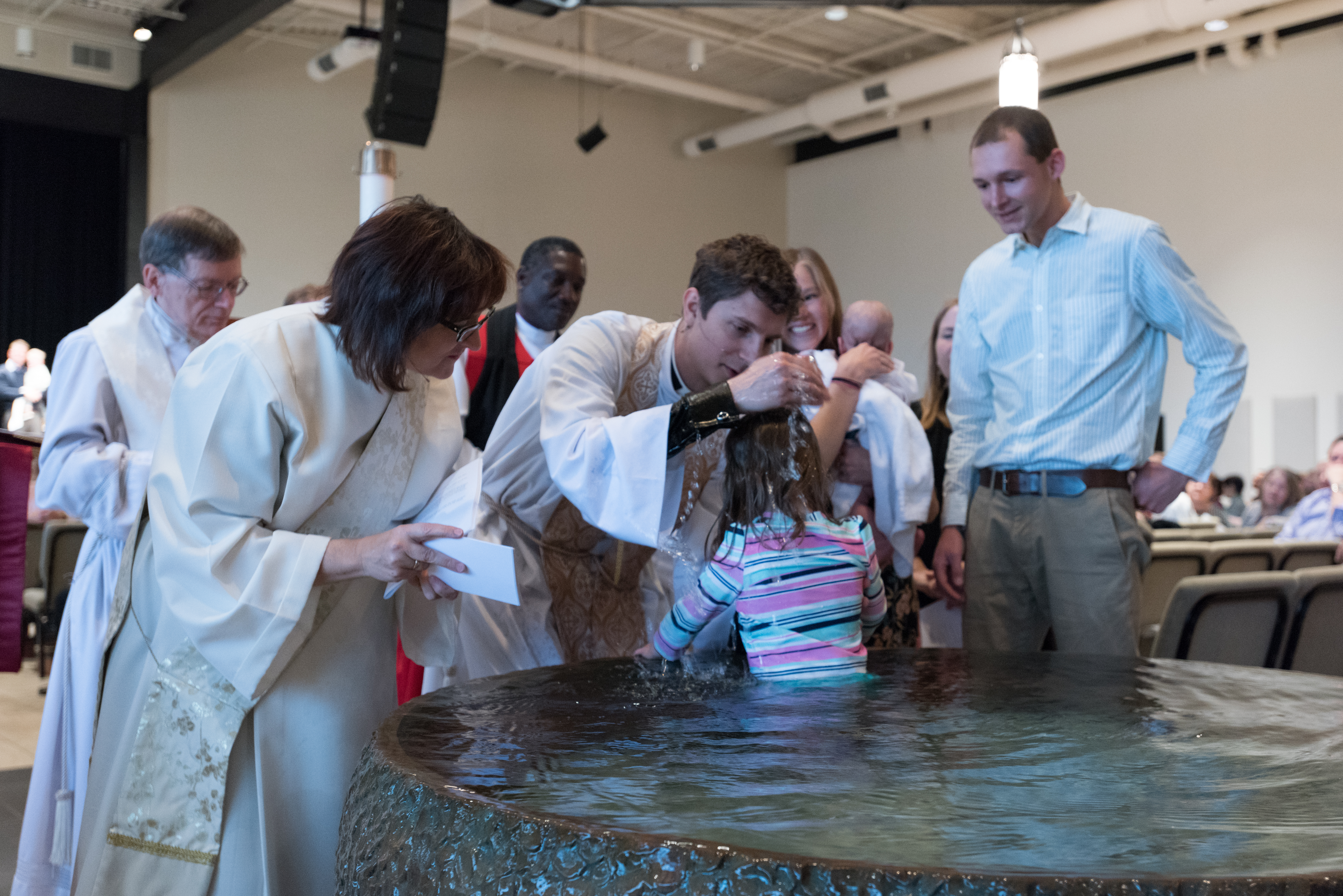 Anglican baptism service, child being baptized by priest